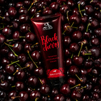 2BTanned Black Cherry Tanning Accelerator Cream on bed of fresh cherries – cherry scented tanning lotion