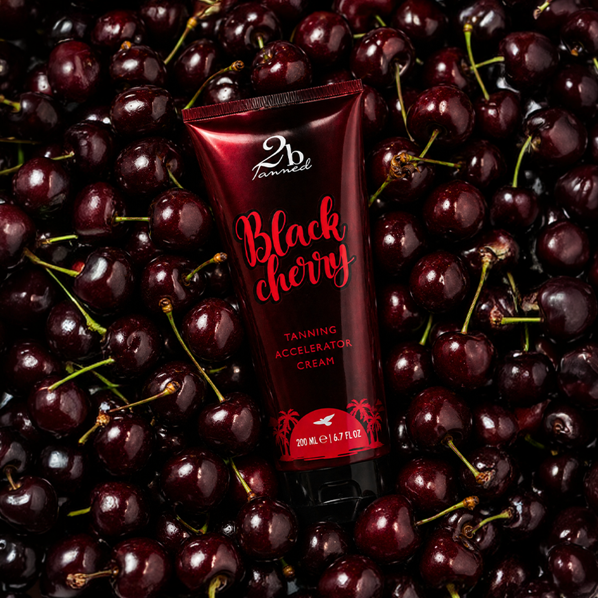 2BTanned Black Cherry Tanning Accelerator Cream on bed of fresh cherries – cherry scented tanning lotion